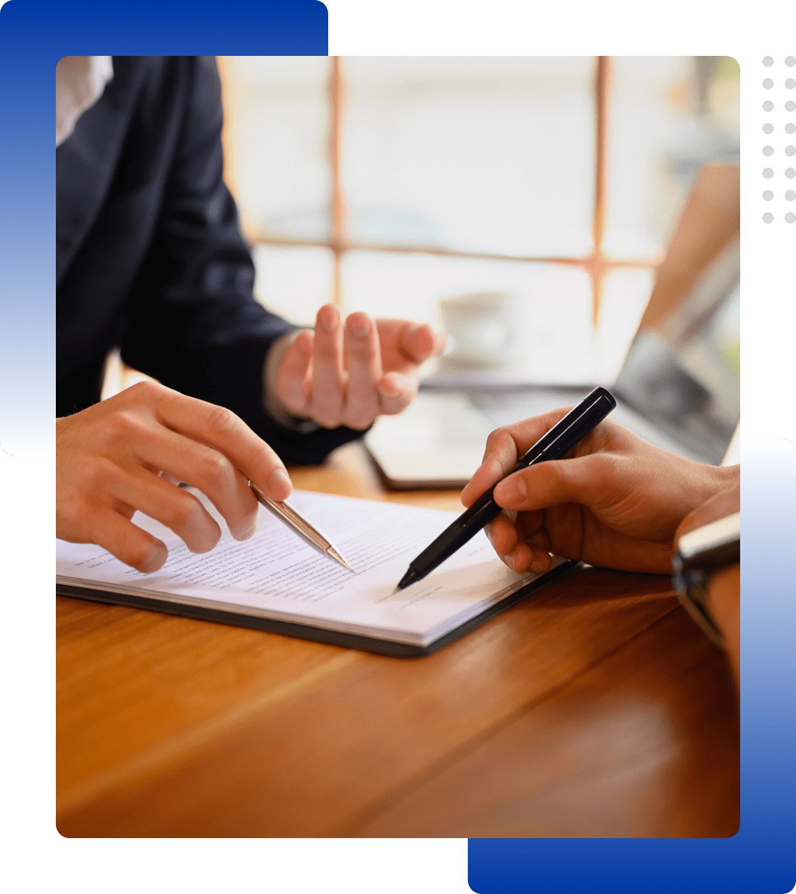 Two people discussing notes and writing in a notebook during a meeting.