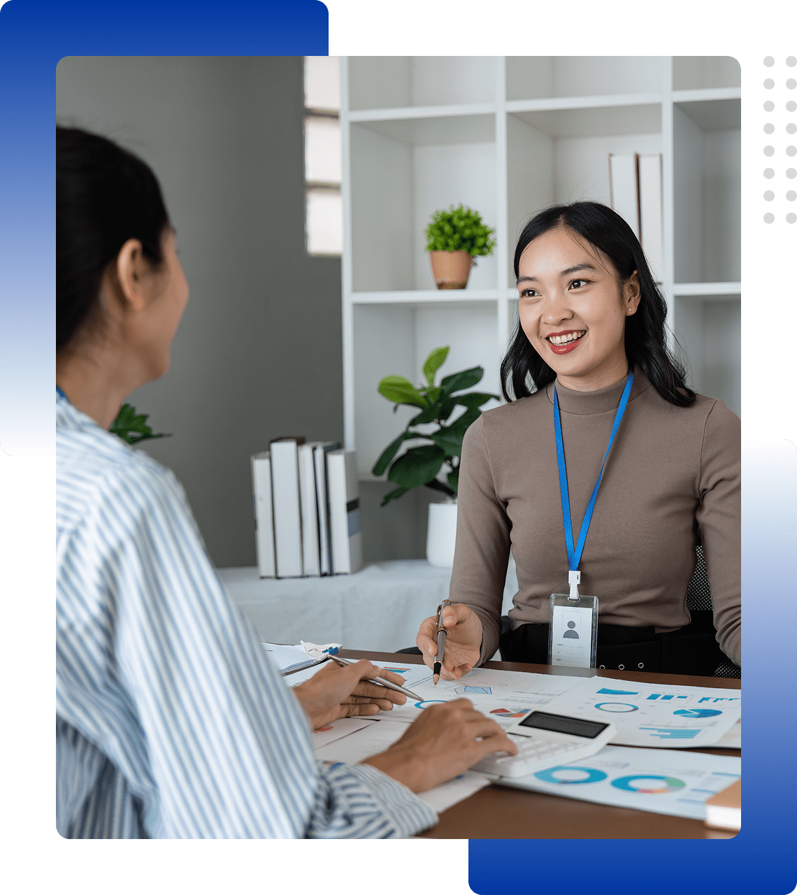 Two women engaged in a professional business meeting with documents.