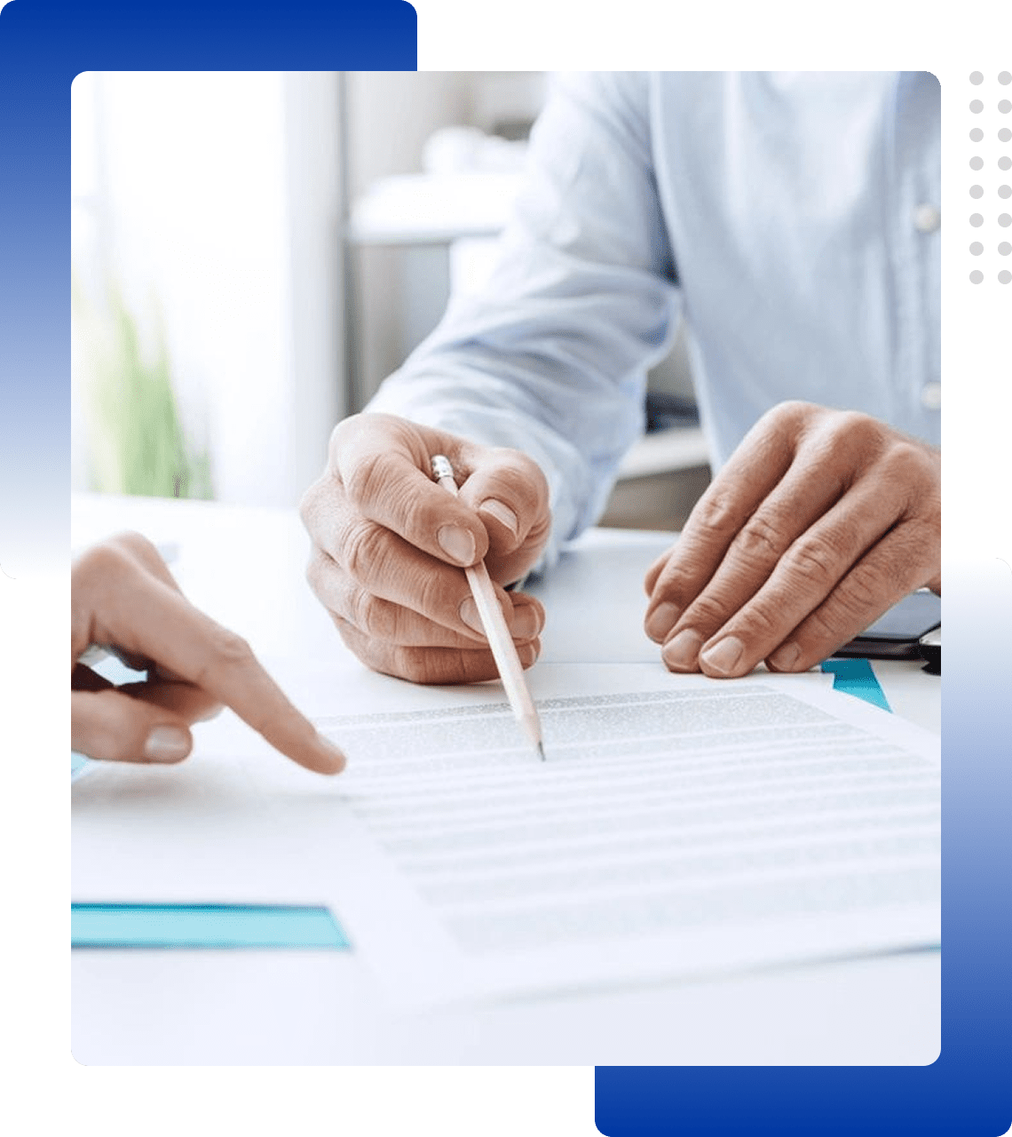 Two people reviewing and pointing at a document with a pen.