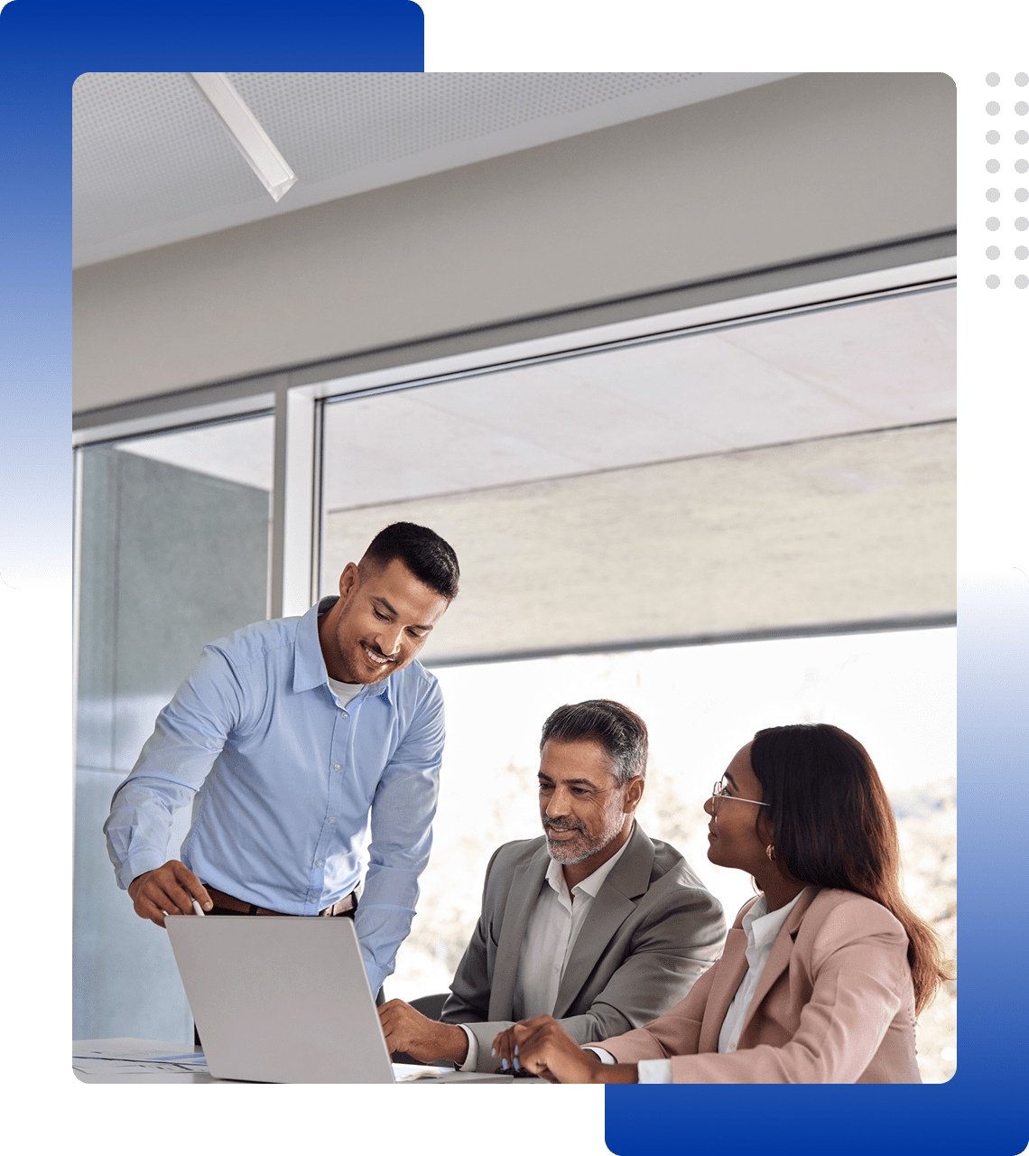 Three colleagues collaborating over a laptop in an office.